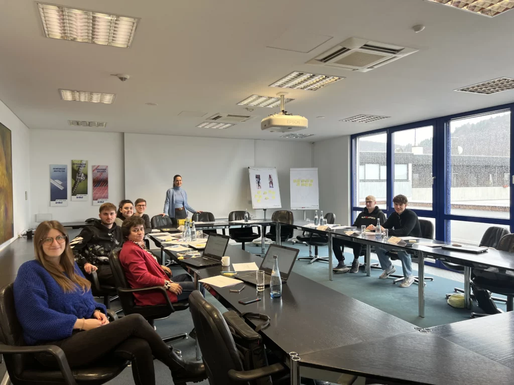 Auszubildende der Firma bardusch sitzen mit einer Trainerin in einem Seminarraum w&auml;hrend einer Kommunikationsschulung.