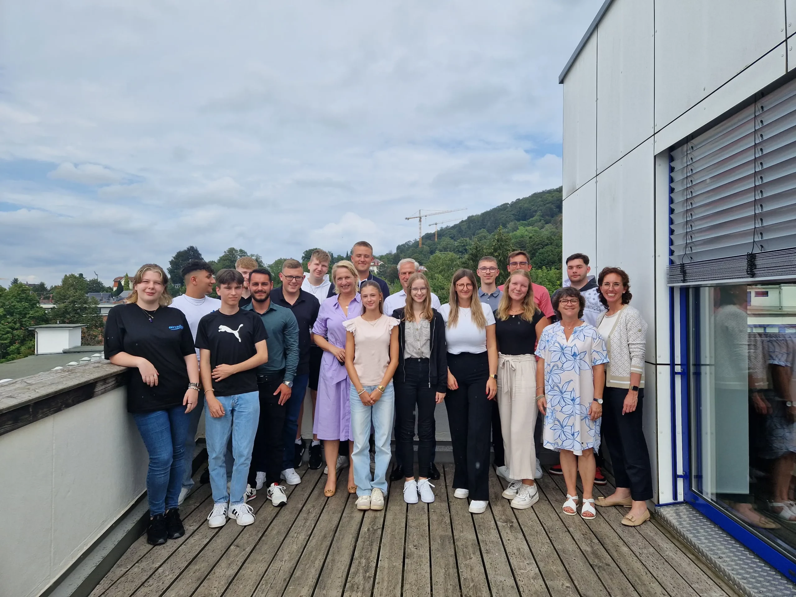 Gruppe von bardusch-Azubis steht gemeinsam vor dem Firmengeb&auml;ude und l&auml;chelt in die Kamera mit Christina Bardusch zum Abschluss der Einstiegstage