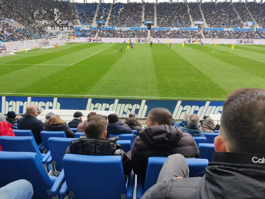 Azubis sitzen an ihren Plätzen und schauen dem Fußballspiel zu.