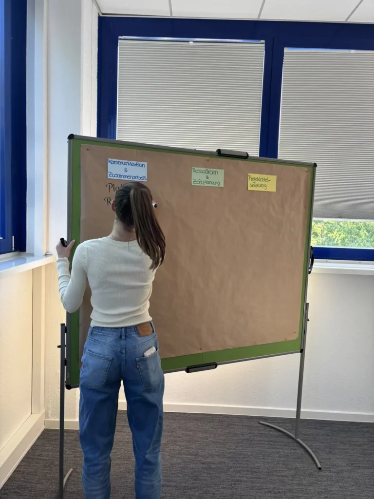 Tafelschreiben für Projektmanagement Schulung Azubi schreibt Informationen auf eine Tafel während einer Schulung