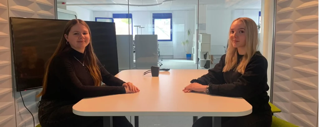 Zwei Auszubildende sitzend an einem Tisch