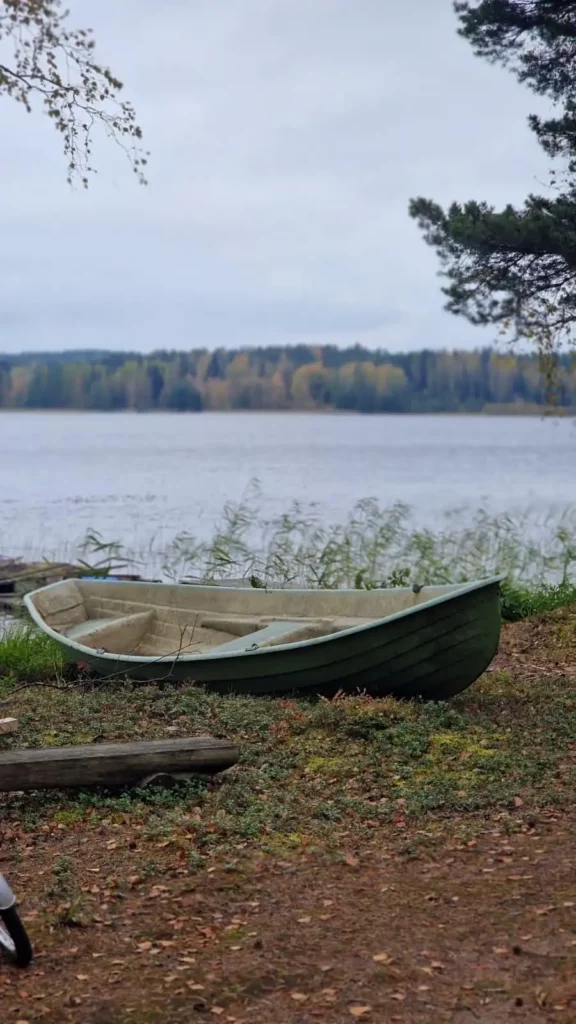 Herbstliche Seenlandschaft in Finnland Ruderboot am Ufer eines finnischen Sees im Herbst