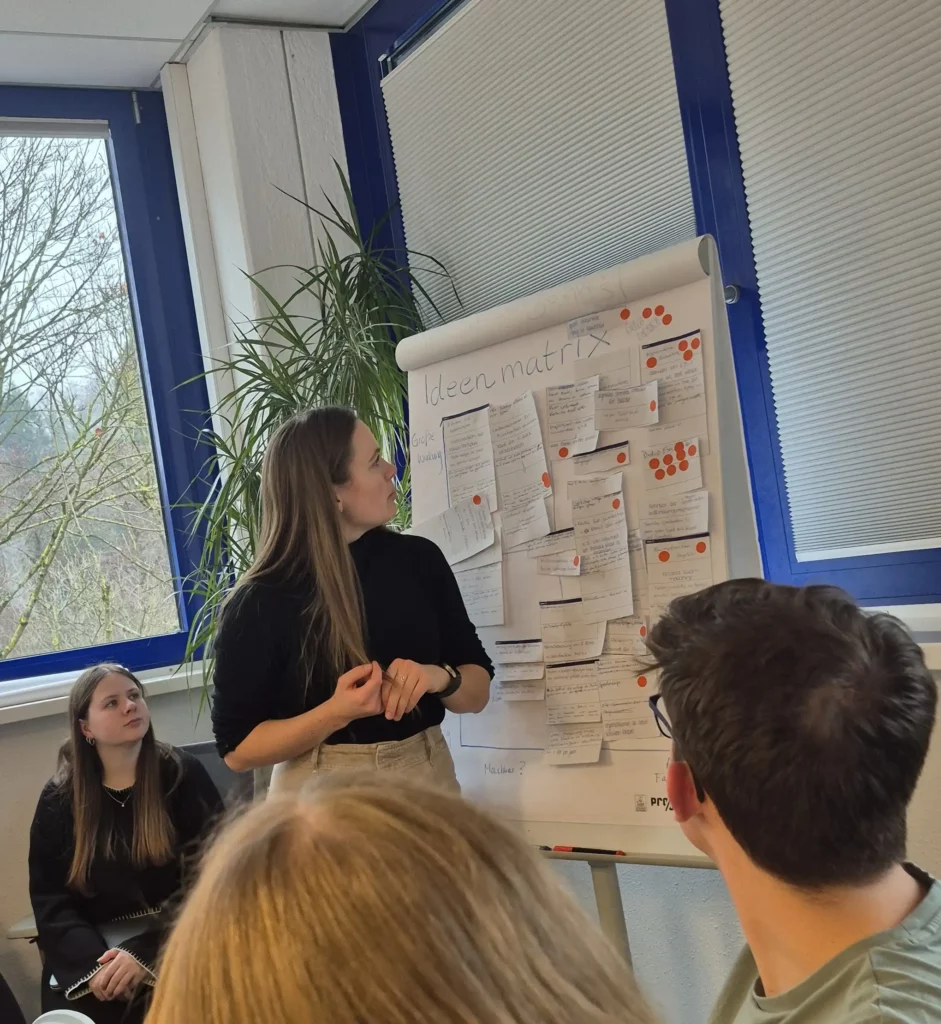 Azubis pr&auml;sentieren ihre Nachhaltigkeitsideen an einer Pinnwand und bewerten diese nach Umsetzbarkeit und Wirkung