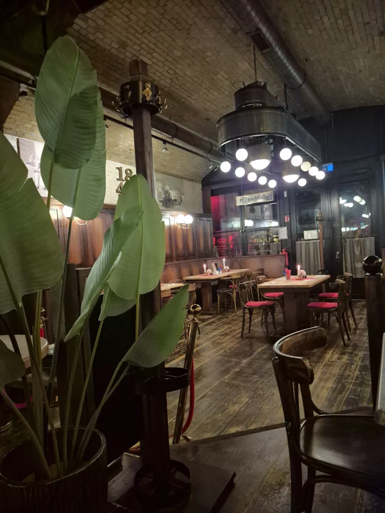 Gemütlicher Restaurantinnenraum in Berlin mit Pflanzen und Sitzgelegenheiten während des Kongressbesuchs