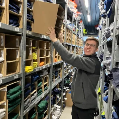 Auszubildender von bardusch beim SCM-Einsatz in Polen zwischen Regalen eines Warenlagers